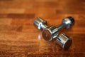 Chrome dumbells on wooden brown parquet floor of the gym Royalty Free Stock Photo