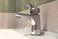 chrome faucet washbasin. Closed the tap dripping water in the bathroom. Waste of water. crane silver color with white sink in the Royalty Free Stock Photo