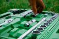 Chrome mechanics tools set. Close-up photo of a set of sockets with a screwdriver and a ratchet in a green plastic case against a Royalty Free Stock Photo