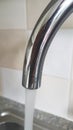 Chrome plated tap at home where water is coming out..