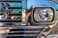 Chrome radiator grille and headlight of a filipino Jeepney in the Philippines. A refurbished bus for public transportation.