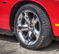Chrome wheel of a red muscle car