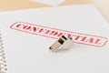 Chrome whistle on documents with confidential top secret information on wooden office desk - whistleblower concept Royalty Free Stock Photo