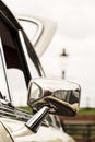 Chrome wing mirror of a restored Austin Marina open during a Classic Car Rally