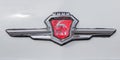 Chromed emblem of blue retro car Volga with deer and inscription GAZ