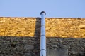 Chromed metal smokestack attached to a dry stone wall