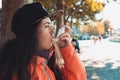 Chronic disease. Portrait of a teenage girl using an inhaler on the street, having an asthma attack. Side view. Outdoor Royalty Free Stock Photo