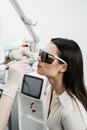 Chronic rhinitis treatment with laser. ENT doctor in protective glasses holding surgical laser and doing laser treatment Royalty Free Stock Photo