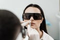 Chronic rhinitis treatment with laser. ENT doctor in protective glasses holding surgical laser and doing laser treatment Royalty Free Stock Photo