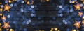 Christmas celebration decoration background banner - Frame made of golden star light chain and bokeh lights on dark black wooden Royalty Free Stock Photo