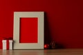 Chrsitmas decorations and wooden frame with copy space on red background