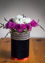 Chrysanthenums in a rustic black velvet covered vase with embroidered ribbon band - Purple and white flower arrangement on wooden