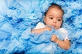 Chubby African small baby laying on the blue cloth