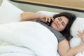 Chubby Asian teen girl is laying in bed and talking on the phone with friends Royalty Free Stock Photo