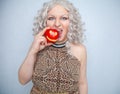 Chubby blonde girl wearing summer dress and posing with big red apple on white background alone Royalty Free Stock Photo