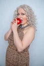 Chubby blonde girl wearing summer dress and posing with big red apple on white background alone Royalty Free Stock Photo