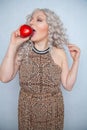 Chubby blonde girl wearing summer dress and posing with big red apple on white background alone Royalty Free Stock Photo