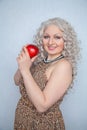 Chubby blonde girl wearing summer dress and posing with big red apple on white background alone Royalty Free Stock Photo