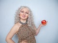 Chubby blonde girl wearing summer dress and posing with big red apple on white background alone Royalty Free Stock Photo