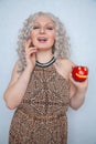 Chubby blonde girl wearing summer dress and posing with big red apple on white background alone Royalty Free Stock Photo