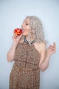 Chubby blonde girl wearing summer dress and posing with big red apple on white background alone Royalty Free Stock Photo