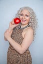 Chubby blonde girl wearing summer dress and posing with big red apple on white background alone Royalty Free Stock Photo