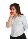 Chubby girl in white shirt eats tomato.