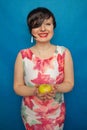 Chubby plus size woman holding green apple on blus studio solid background