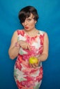 Chubby plus size woman holding green apple on blus studio solid background