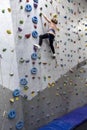 Chubby pretty Caucasian girl climbering artificial rock-climbing walls Royalty Free Stock Photo