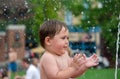 Chubby toddler in water fountain