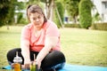 Chubby tried woman looking to glass of sweet drinks on natural garden in new normal condition after Corona epidemic.weight woman g