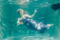 Chubby woman in grey evening long dress swimming underwater on her holidays and enjoy with relax Royalty Free Stock Photo