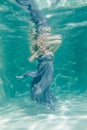 Chubby woman in grey evening long dress swimming underwater on her holidays and enjoy with relax Royalty Free Stock Photo