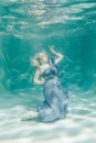 Chubby woman in grey evening long dress swimming underwater on her holidays and enjoy with relax Royalty Free Stock Photo