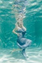 Chubby woman in grey evening long dress swimming underwater on her holidays and enjoy with relax Royalty Free Stock Photo