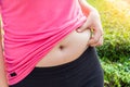 Chubby woman hand holding her own belly fat. Royalty Free Stock Photo