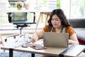 Chubby woman looking at laptop computer and writing on notebook for work or study Royalty Free Stock Photo