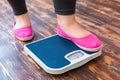 Chubby woman sport at home standing on scales checking weight close-up