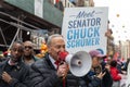 Chuck Schumer standing in front of a crowd, raising a megaphone and talking to them
