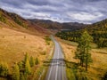 Chui tract road goes through the autumn landscape, the yellow and green hills and forests of Altai mountains in Russia. Royalty Free Stock Photo