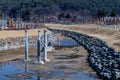 Stone carved ducks atop tall concrete poles in dry man made river