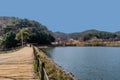 Person wearing face mask walking on path next to pond