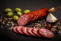 chunk of dry cured salami sausage with onion and green olives Royalty Free Stock Photo