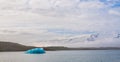 Chunks of glacial ice float in a calm lagoon