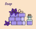 Chunks of hard purple soap tied with a rope, flowers, lavender oil in a bottle, on a beige background