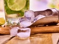 Chunks of ice cubes alcohol drink background on wooden boards.