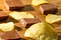 Chunks of milk chocolate and potato chips Royalty Free Stock Photo
