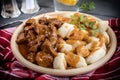 Chunky beef stew with savory sauce beside potato dumplings. Royalty Free Stock Photo