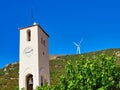 Church Bell and Clock Tower and Modern Electricity Generating Windmill, Greece Royalty Free Stock Photo